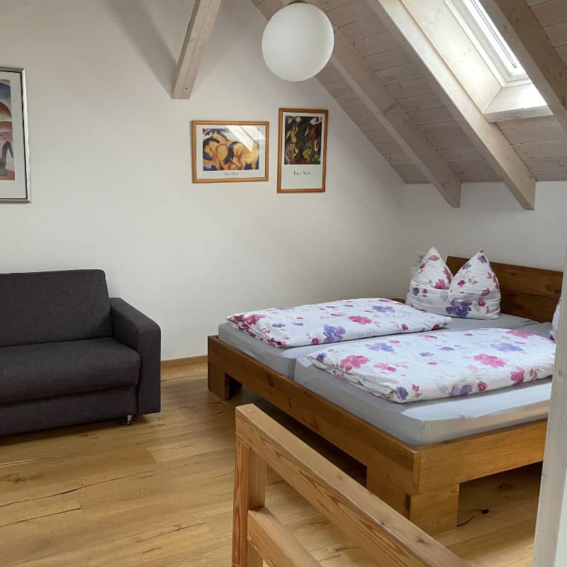 Das Doppelbett im offenen Schlafzimmer im Obergeschoss des Ferienhauses