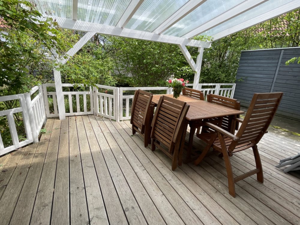 Die Terrasse des Ferienhauses mit Tisch und Stühlen