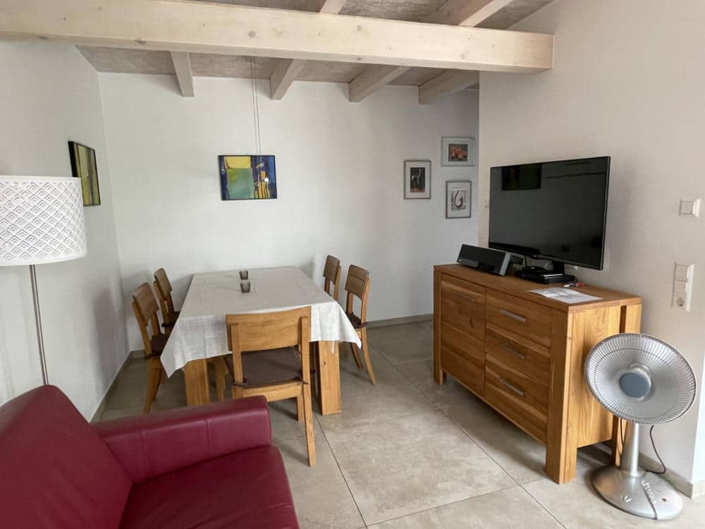 Der Wohnbereich im UG mit Sofa, Esstisch und TV